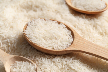 Wooden spoons with raw rice, closeup