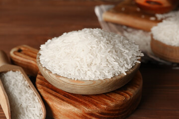 Scoop and bowl of raw rice on table. Closeup