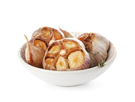 Bowl with baked garlic and thyme on white background