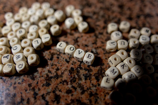 Wooden alphabet blocks spelling love resting on polished marble background
