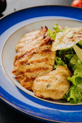 Grilled chicken salad with cheese slices, bacon, lettuce, and crispy bread for a hearty, fresh meal