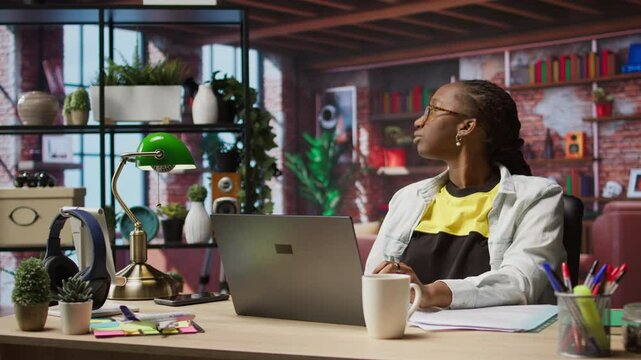 Remote employee pausing work done on laptop at home to pensive thinking. Teleworker in apartment feeling bored by repetitive tasks, stopping work on notebook to daydream, camera A