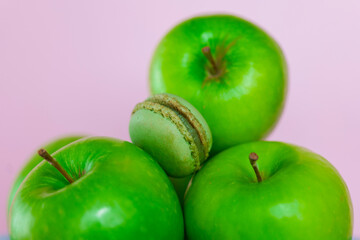 green apple macaroons on a pink background.French pastries set. Fruit pastries with apple aroma and cream.Sweets and desserts. 