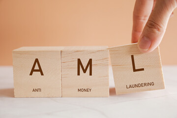 Hand holding blocks with AML anti money laundering business concept