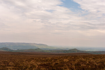 A vast, empty field with a cloudy sky in the background