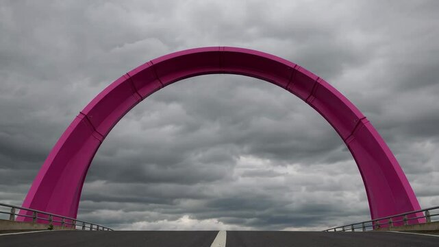 Pink arch bridge over highway under cloudy sky, modern architecture concept