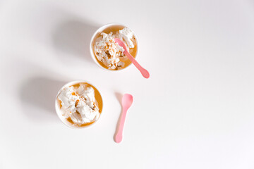 Minimalist white background with ice cream boxes and cute pink spoons. Mockup for design, template with copy space, flat lay