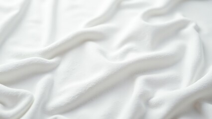 Fototapeta premium Wrinkled, creamy-white fabric with smooth, wavelike textures captured in an intimate close-up view. The surface gleams with subtle undulations