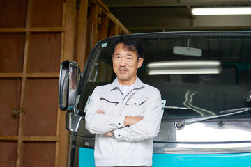 トラックの前に立つ男性作業員のポートレート