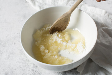 Creaming oil and sugar with a wooden spoon, the process of making a cake and cookies, mixing butter and sugar to make a cake and cookies