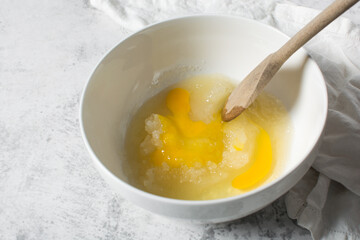 Creaming oil sugar and egg with a wooden spoon, the process of making a cake and cookies, mixing butter and sugar to make a cake and cookies