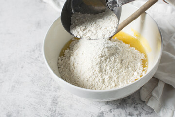 overhead view of All purpose flour in a measuring cup, baking flour in a steel measuring cup
