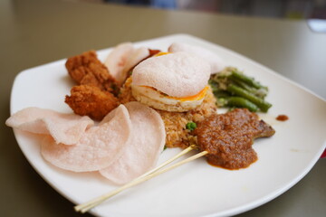 Nasi Goreng is a popular Indonesian fried rice dish known for its rich flavors, aromatic spices, and signature dark brown color from sweet soy sauce (kecap manis).  
