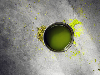 Matcha Green tea drink in tea cup and Japanese dry green tea leaves for health brewing with soft sunlight in the morning