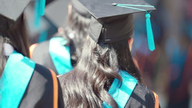 A group of people wearing graduation gowns and caps. Concept of accomplishment and pride as the graduates celebrate their achievements