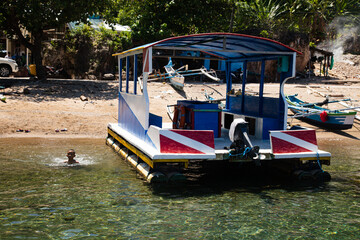 Naklejka premium Two traditional pontoon-style catamaran boats with glass in the middle hull await tourists to sail to see the fish and coral