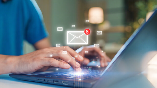 Close-up of hands typing on a laptop keyboard with floating email icons and notification alerts. Concept of digital communication, email management, and technology in modern work.