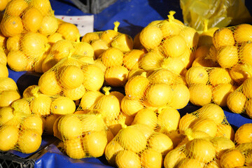 Fresh Yellow Lemons in Convenient Net Bags Available at Local Market