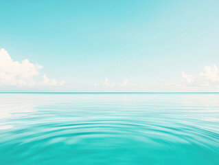 Obraz premium Calm turquoise ocean with ripples under clear sky and soft white clouds