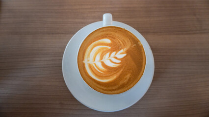 latte art in a white cup, on a wooden table