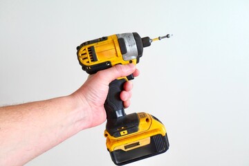 Cordless drill in hand on a white background close-up