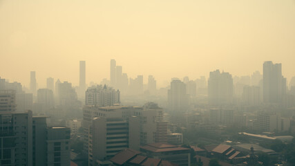 cityscape of high rise buildings in poor weather morning, haze of pollution covers city, global warming concept, PM2.5 particles, health effects
