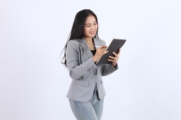 Fototapeta premium Hppy woman in a gray jacket is writing on a book. Business asian woman