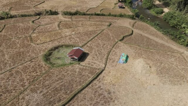 Aerial footage over a rice field and a hole made by a B52 during the secret war in Lao PDR 1964-1973