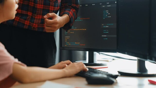 Slow motion back end or software developer manager supervising his team on new application program development on debugging and solving complex code algorithms on monitor. Burgeoning
