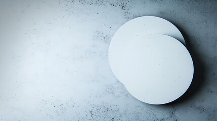 Two white circles subtly overlap on a cool grey textured background Soft light enhances minimalist aesthetic. AI Generated