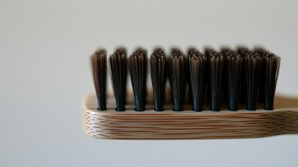 Close-up bamboo toothbrush bristles, light background, hygiene, sustainable.