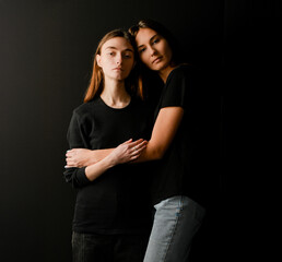 portrait of two hugging girls on a dark background