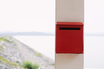Red mailbox installed on the house pillar, leaving space for copying