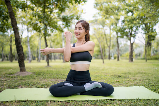 Young asian woman practicing yoga in garden. Healthy lifestyle and relaxation concept.Young Asian Girl doing yoga in the park, copy space. - Powered by Adobe