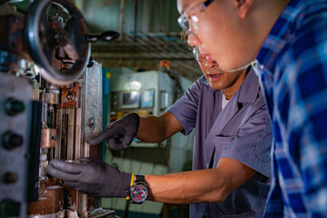 Men are inspecting steel parts for machine installation. team of teacher and student are learning to use heavy machines in steel factory. workers cooperate while doing quality control of manufactured.
