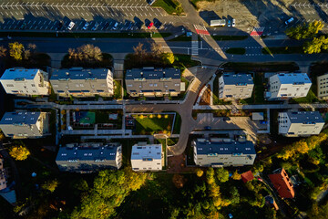 Obraz premium Top view of modern residential neighborhood with contemporary apartment buildings, green spaces, parking areas and well-maintained pathways on sunny day