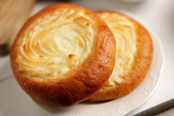 Freshly baked cream cheese pastries on a delicate plate in a cozy bakery setting