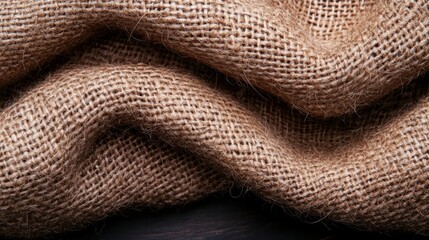A close-up view of a piece of burlap fabric with a textured, woven appearance.