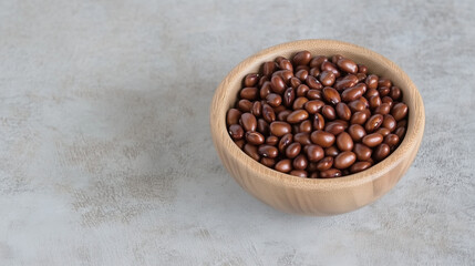 Fototapeta premium Kidney Beans in Wooden Bowl: A rustic wooden bowl brimming with dark red kidney beans, offering a simple yet visually appealing image perfect for culinary or health-related projects.