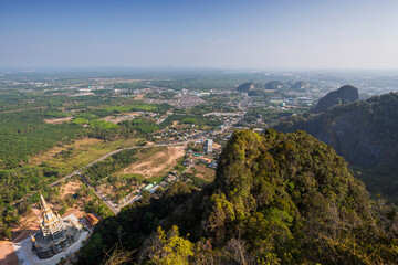 Fototapeta premium Pagoda at the Tiger Cave Temple (Wat Tham Suea (Sua)) and the mountainous surrounding area in Krabi, Thailand, viewed from above on a sunny day.
