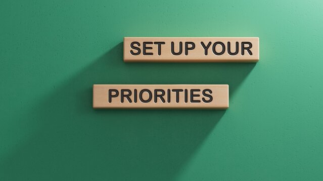 Wooden man shows with a hand to white board with text Set up your priorities. Wooden cube blocks. Copy space.3D rendering on green background.