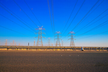 Overhead line pylons, high voltage pylons. Power transmission towers and lines at sunset. A shot of...