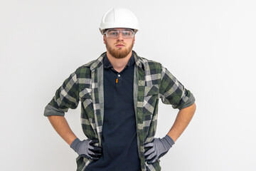 Portrait of a male builder. Engineer in overalls and helmet on a light background.