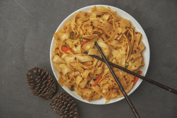 Freshly Made Spicy Handmade Noodles with Stir-Fried Vegetables: A Flavorful and Savory Asian Dish. Chinese hand made noddles in bowl ready to eat...