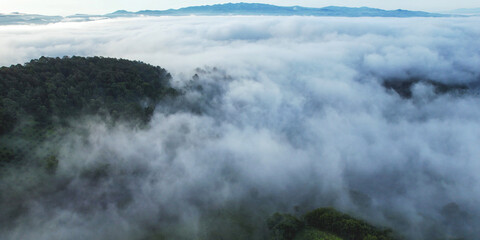 Obraz premium Aerial landscape view of the sea of fog flowing on hills by drone