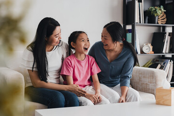 Loving LGBTQ couple shares joyful moment with their adopted daughter in cozy living room