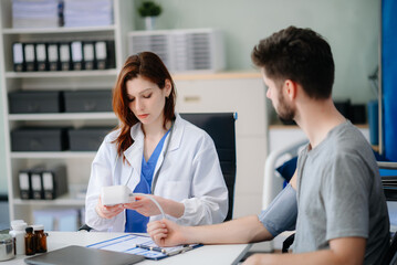 Obraz premium Doctor and patient discussing something while sitting at the table .