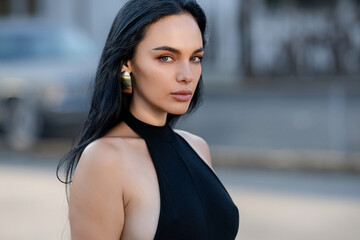 Portrait of Beautiful brunette woman posing on the street. Close-up Fashion woman portrait of young...
