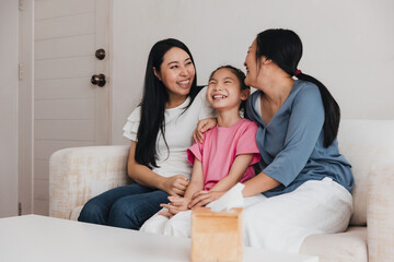Couple enjoying family time with their adopted daughter at home filled with joy and laughter