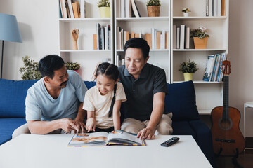 Loving LGBTQ couple engages in family bonding while sharing a storybook with their adopted child at home